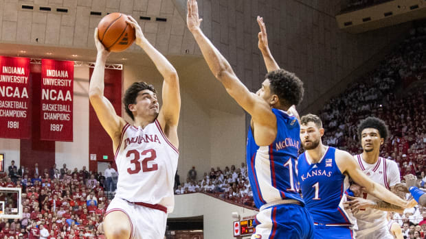 Dec 16, 2023; Bloomington, Indiana, USA; Indiana Hoosiers guard Trey Galloway (32) shoots the ball while Kansas Jayhawks guard Kevin McCullar Jr. (15) defends in the first half at Simon Skjodt Assembly Hall.
