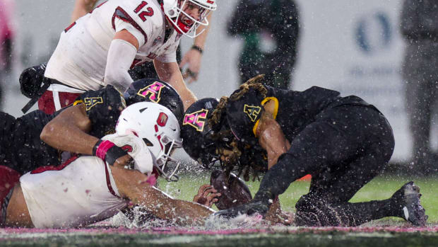Miami (Ohio) and Appalachian State players jostle for one of the 2023 Cure Bowl’s 13 fumbles.