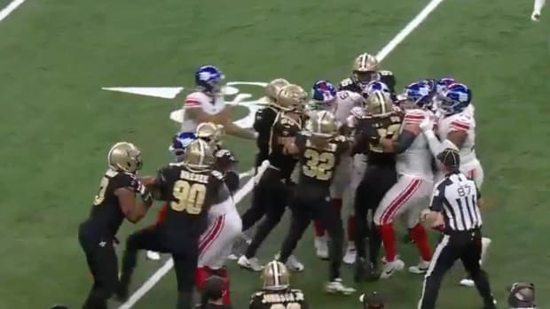Saints and Giants players scuffle on the field after a hit to New York quarterback Tommy DeVito.