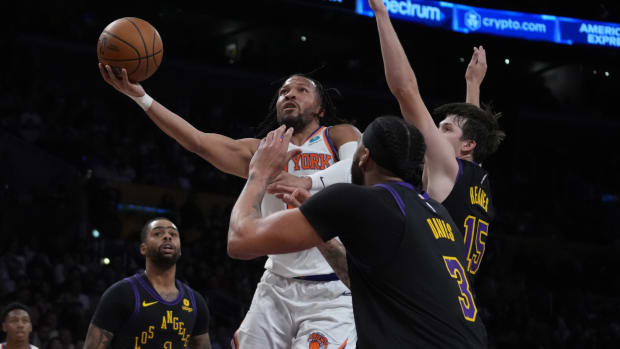 Dec 18, 2023; Los Angeles, California, USA; New York Knicks guard Immanuel Quickley (5) shoots the ball against Los Angeles Lakers guard D'Angelo Russell (1), forward Anthony Davis (3) and guard Austin Reaves (15) in the first half at Crypto.com Arena.