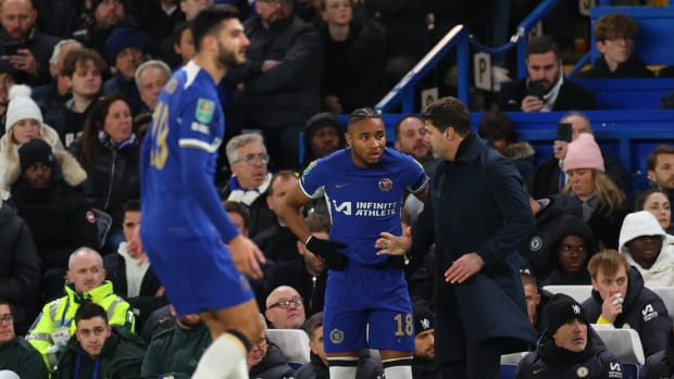 Christopher Nkunku pictured (center) receiving instructions from manager Mauricio Pochettino moments before making his Chelsea debut in an EFL Cup quarter-final against Newcastle in December 2023