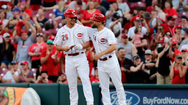 Cincinnati Reds first base coach Collin Cowgill (right) reacts with pinch hitter TJ Hopkins during a game. (2023)