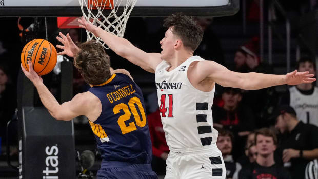 Merrimack Warriors forward Jacob O'Connell (20) drives against Cincinnati Bearcats guard Simas Lukosius (41) in the first half of the NCAA basketball game between the Merrimack Warriors and the Cincinnati Bearcats at Fifth Third Arena in Cincinnati on Tuesday, Dec. 19, 2023.  