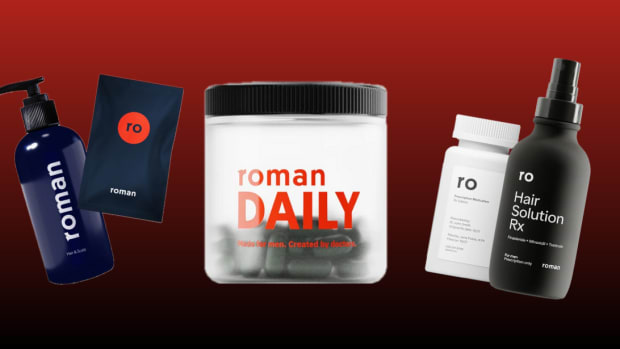 Several bottles and containers of Roman dietary supplements and hair growth products against a red background.