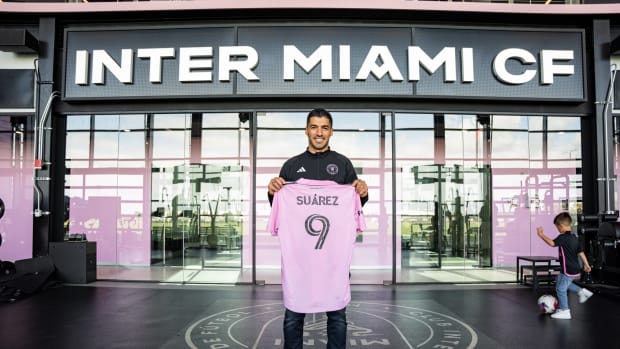Luis Suarez pictured holding an Inter Miami jersey after signing for the Major League Soccer club ahead of the 2024 season