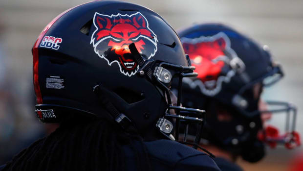 Two Arkansas State players where Red Wolves helmers during a game.