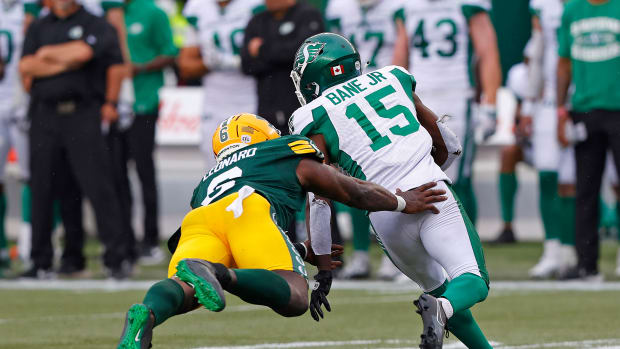 Jun 11, 2023; Edmonton, Alberta, CAN; Saskatchewan Roughriders wide receiver Shawn Bane Jr. (15) avoids a tackle by Edmonton Elks defensive lineman A.C. Leonard (6) during the second half at Commonwealth Stadium. Mandatory Credit: Perry Nelson-USA TODAY Sports  