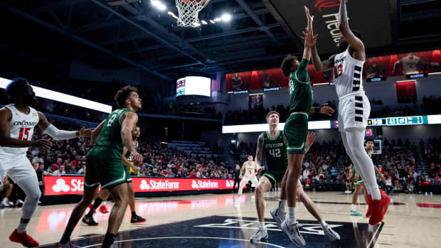 Cincinnati Bearcats forward Jamille Reynolds (13) hits a basket over Stetson Hatters center Aubin Gateretse (21) in the second half of the basketball game between Cincinnati Bearcats and Stetson Hatters at Fifth Third Arena in Cincinnati on Friday, Dec. 22, 2023
