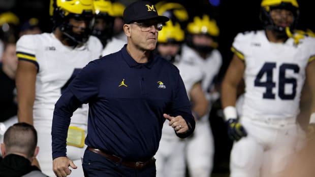Michigan Wolverines football coach Jim Harbaugh leads his team onto the field at the Big Ten championship game against the Iowa Hawkeyes on Dec. 2, 2023.