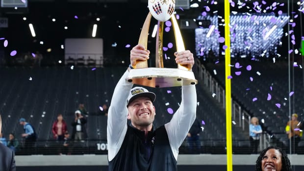 Northwestern Wildcats head coach David Braun hoists the Las Vegas Bowl trophy after the Wildcats defeated the Utah Utes 14-7 at Allegiant Stadium.