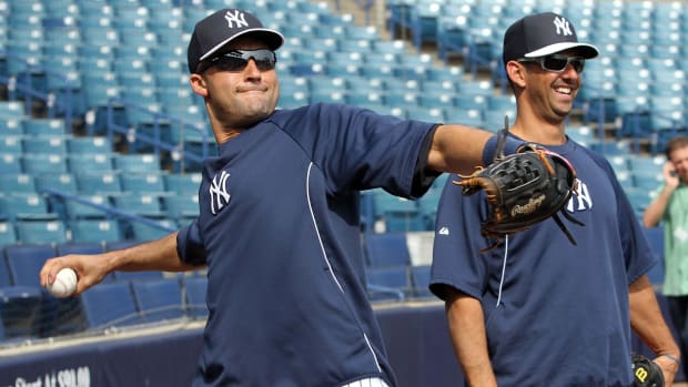 February 27, 2013; Tampa, FL, USA; New York Yankees shortstop Derek Jeter (left) throws a ball while standing with special instructor Jorge Posada prior to the spring training game against the Baltimore Orioles at George M. Steinbrenner Field. Mandatory Credit: Kim Klement-USA TODAY Sports