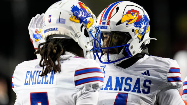 Kansas Jayhawks running back Devin Neal (4), right, pats Kansas Jayhawks wide receiver Doug Emilien (5) s helmet after Neal (4) scores a touchdown during the NCAA college football game between the Cincinnati Bearcats and Kansas Jayhawks on Saturday, Nov. 25, 2023, at Nippert Stadium in Cincinnati. This is the Bearcats last game of the season, as well as their Senior Night Saturday.  