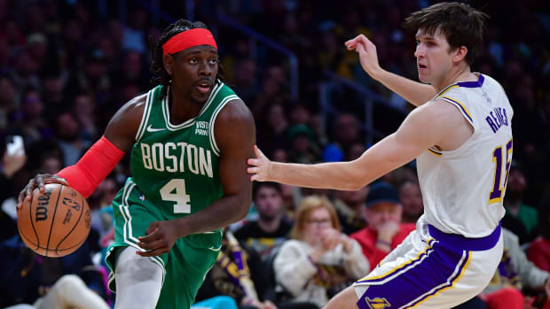 Celtics guard Jrue Holiday, left, dribbles past Lakers guard Austin Reaves