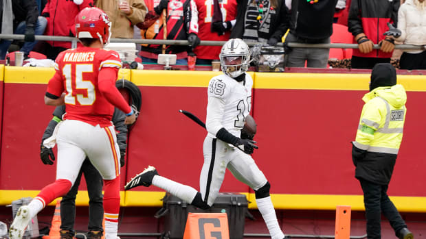 Las Vegas Raiders cornerback Jack Jones scores after intercepting a pass and running it back for a touchdown as Kansas City Chiefs quarterback Patrick Mahomes watches.