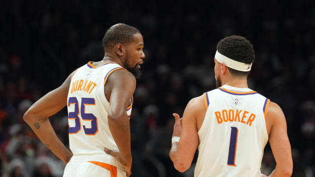 Phoenix Suns forward Kevin Durant (35) and Phoenix Suns guard Devin Booker (1) look on against the Dallas Mavericks at Footprint Center.