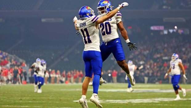 Dec 26, 2023; Phoenix, AZ, USA; Kansas Jayhawks wide receiver Luke Grimm (11) celebrates with running back Daniel Hishaw Jr. (20) after scoring a touchdown during the second quarter against the UNLV Rebels in the Guaranteed Rate Bowl at Chase Field.