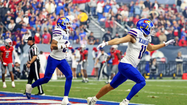 Dec 26, 2023; Phoenix, AZ, USA; Kansas Jayhawks wide receiver Luke Grimm (11) celebrates after scoring a touchdown during the second quarter against the UNLV Rebels in the Guaranteed Rate Bowl at Chase Field. Mandatory Credit: Mark J. Rebilas-USA TODAY Sports  