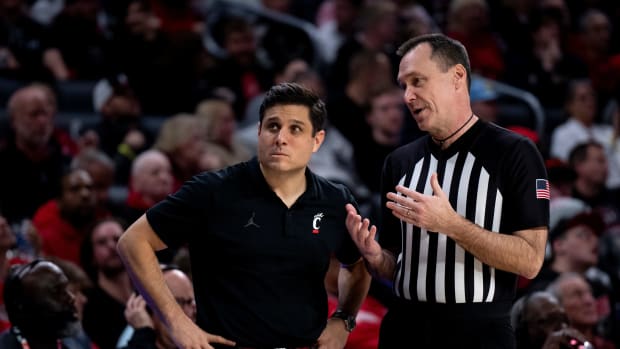 Cincinnati head coach Wes Miller stands next to a referee in the second half of the basketball game between Cincinnati Bearcats and Stetson Hatters at Fifth Third Arena in Cincinnati on Friday, Dec. 22, 2023.