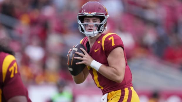USC Trojans quarterback Miller Moss looks downfield to attempt a pass during a college football game.