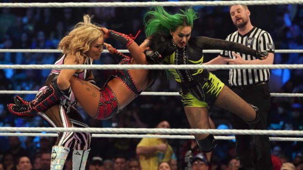 Shotzi (green attire) and Natalya (pink attire) attack Xia Li during WWE Smackdown.