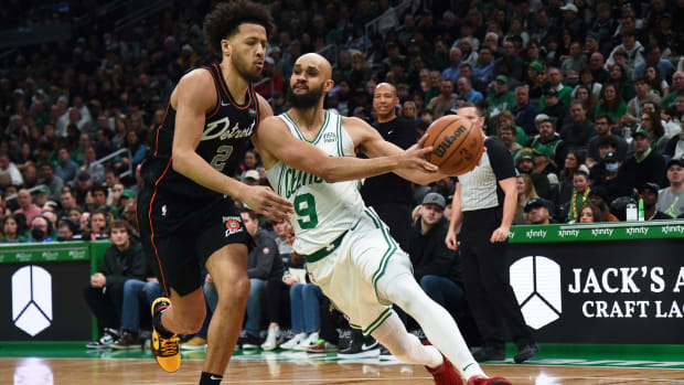 Boston Celtics guard Derrick White controls the ball while Detroit Pistons guard Cade Cunningham defends.