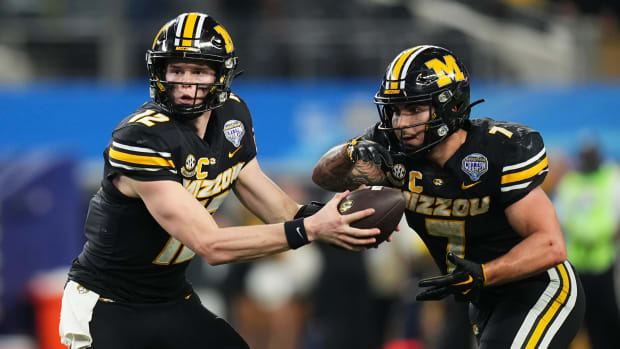 Missouri Tigers quarterback Brady Cook (12) hands off to running back Cody Schrader (7) during the fourth quarter of the Goodyear Cotton Bowl Classic against the Ohio State Buckeyes at AT&T Stadium. Ohio State lost 14-3.