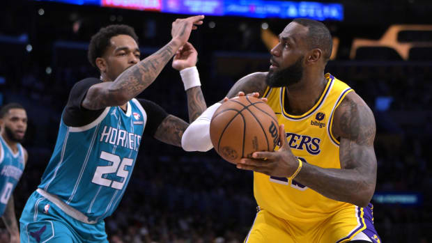Charlotte Hornets forward P.J. Washington (25) defends Los Angeles Lakers forward LeBron James (23) in the first half at Crypto.com Arena in Los Angeles on Dec. 28, 2023.