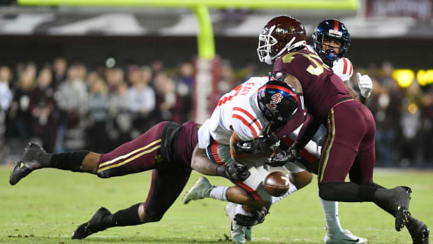 Nov 28, 2019; Starkville, MS, USA; Mississippi Rebels running back Jerrion Ealy (9) fumbles the ball as he is hit by Mississippi State Bulldogs linebacker Erroll Thompson (40) and safety Brian Cole II (32) during the first quarter at Davis Wade Stadium. Mandatory Credit: Matt Bush-USA TODAY Sports  