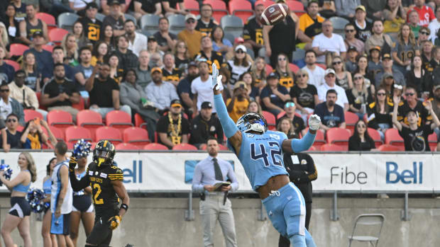 Jun 18, 2023; Toronto, Ontario, CAN; Toronto Argonauts defensive back Qwan'tez Stiggers (42) reaches up to intercept a pass intended for Hamilton Tiger-Cats wide receiver Tim White (12) in the first quarter at BMO Field. Mandatory Credit: Dan Hamilton-USA TODAY Sports
