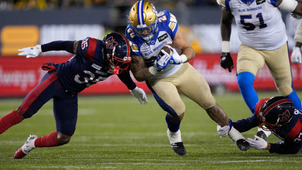 Nov 19, 2023; Hamilton, Ontario, CAN; Winnipeg Blue Bombers running back Brady Oliveira (20) gets tackled by Montreal Alouettes defensive back Reggie Stubblefield (35) and defensive back Wesley Sutton (37) during the 110th Grey Cup game at Tim Hortons Field. Mandatory Credit: John E. Sokolowski-USA TODAY Sports  