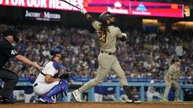 Sep 13, 2023; Los Angeles, California, USA; San Diego Padres right fielder Fernando Tatis Jr. (23) hits a two-run single in the seventh inning as Los Angeles Dodgers catcher Austin Barnes (15) watches at Dodger Stadium.