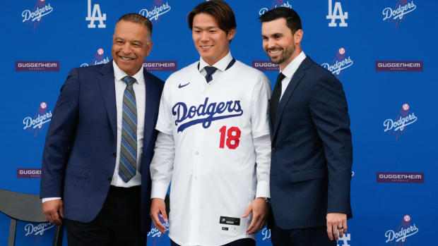 Yoshinobu Yamamoto, center, poses for a photo with manager Dave Roberts, left, and Executive Vice President and General Manager Brandon Gomes during his introduction as a new member of the Los Angeles Dodgers baseball team Wednesday, Dec. 27, 2023, in Los Angeles. (AP Photo/Damian Dovarganes)   