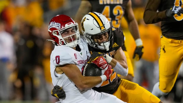Oct 7, 2023; Laramie, Wyoming, USA; Fresno State Bulldogs wide receiver Mac Dalena (0) is tackled by Wyoming Cowboys safety Isaac White (42) during the fourth quarter at Jonah Field at War Memorial Stadium.