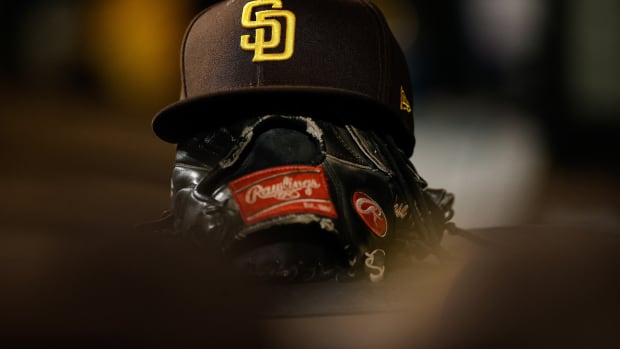 Jun 17, 2022; Denver, Colorado, USA; A detail view of a San Diego Padres hat on a glove in the dugout in the ninth inning against the Colorado Rockies at Coors Field. Mandatory Credit: Isaiah J. Downing-USA TODAY Sports  