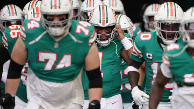 Miami Dolphins quarterback Tua Tagovailoa (1) puts his helmet on before heading out to warm-up before the NFL game against the Dallas Cowboys at Hard Rock Stadium in Miami Gardens, Dec. 24, 2023.