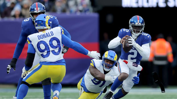 Dec 31, 2023; East Rutherford, New Jersey, USA; New York Giants quarterback Tyrod Taylor (2) is sacked by Los Angeles Rams defensive tackles Kobie Turner (91) and Aaron Donald (99) during the third quarter at MetLife Stadium.
