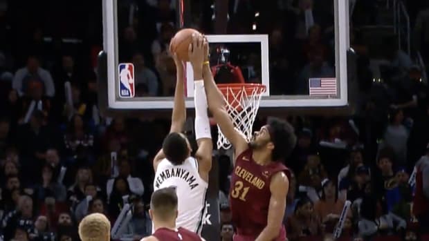 Spurs rookie Victor Wembanyama attempts to dunk the ball but Cavaliers center Jarrett Allen blocks the shot.