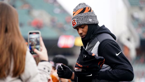 Cincinnati Bengals wide receiver Tee Higgins (5) signs autographs for fans during pregame warm ups prior to a Week 18 NFL football game between the Cleveland Browns at Cincinnati Bengals, Sunday, Jan. 7, 2024, at Paycor Stadium in Cincinnati.  