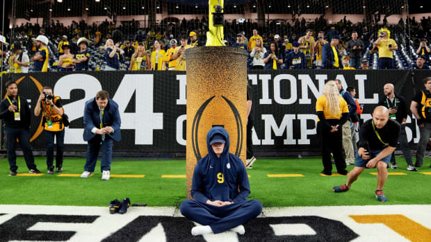 Michigan quarterback J.J. McCarthy meditates on the field before the start of the College Football Playoff national championship game against Washington at NRG Stadium in Houston.