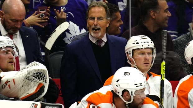 Flyers head coach John Tortorella calls out to his team from the bench during a game.