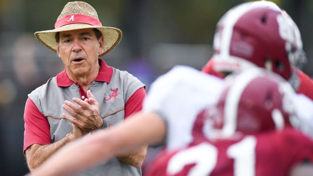 Alabama coach Nick Saban claps while observing a team practice.