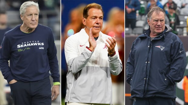Pete Carroll walks with a hand in his pocket; Nick Saban claps; Bill Belichick stands with his hands in his jacket pockets