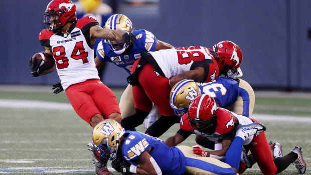 Aug 25, 2022; Winnipeg, Manitoba, CAN; Calgary Stampeders wide receiver Reggie Begelton (84) is tackled by Winnipeg Blue Bombers defensive back Jamal Parker (45) during the first half at IG Field. Mandatory Credit: Bruce Fedyck-USA TODAY Sports  