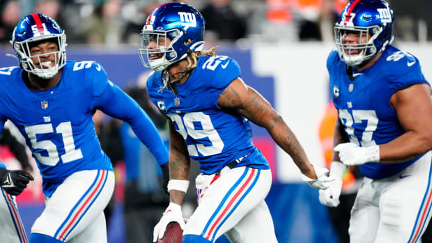 New York Giants safety Xavier McKinney (29) holds the ball as he celebrates with New York Giants linebacker Azeez Ojulari (51) and New York Giants defensive tackle Dexter Lawrence II (97) after he intercepted a Philadelphia Eagles pass on Sunday, January 7, 2024.