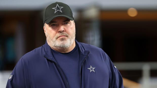 Mike McCarthy staring ahead and wearing a Cowboys hat