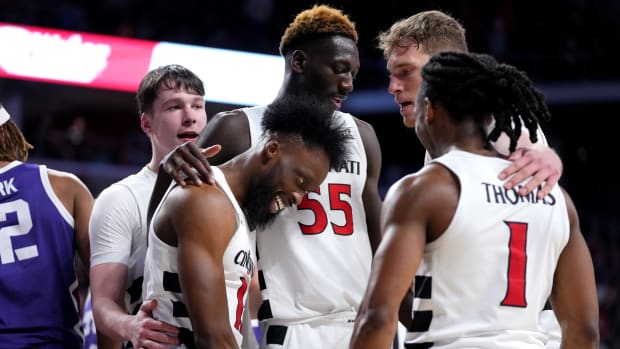 Cincinnati Bearcats forward John Newman III (15) is embraced by teammates after a made basket in the second half of a college basketball game between the TCU Horned Frogs and the Cincinnati Bearcats, Tuesday, Jan. 16, 2024, at Fifth Third Arena in Cincinnati. The Cincinnati Bearcats won, 81-77.