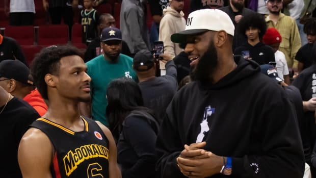 Lakers star LeBron James speaks with his son Bronny at the 2023  McDonald's All American Boy's high school basketball game.
