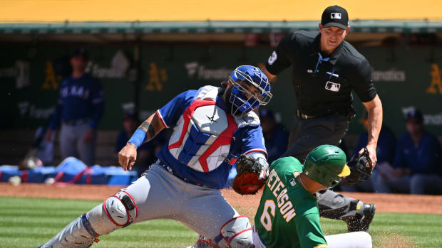 May 13, 2023; Oakland, California, USA; Texas Rangers catcher Sandy Leon (12) tags out Oakland Athletics infielder Jace Peterson (6) during the seventh inning at Oakland-Alameda County Coliseum.