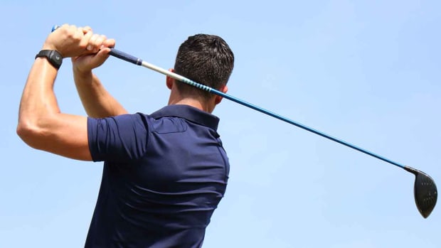 The deWiz Golf training aid is pictured on the wrist while a player swings a driver.