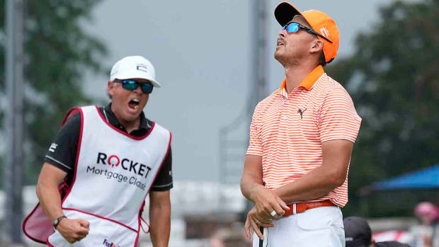 Rickie Fowler looks skyward as his caddie Ricky Romano yells after Fowler's win at the 2023 Rocket Mortgage Classic.
